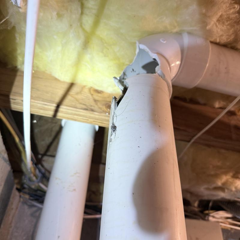PVC drain pipe cracked near elbow joint in ceiling cavity