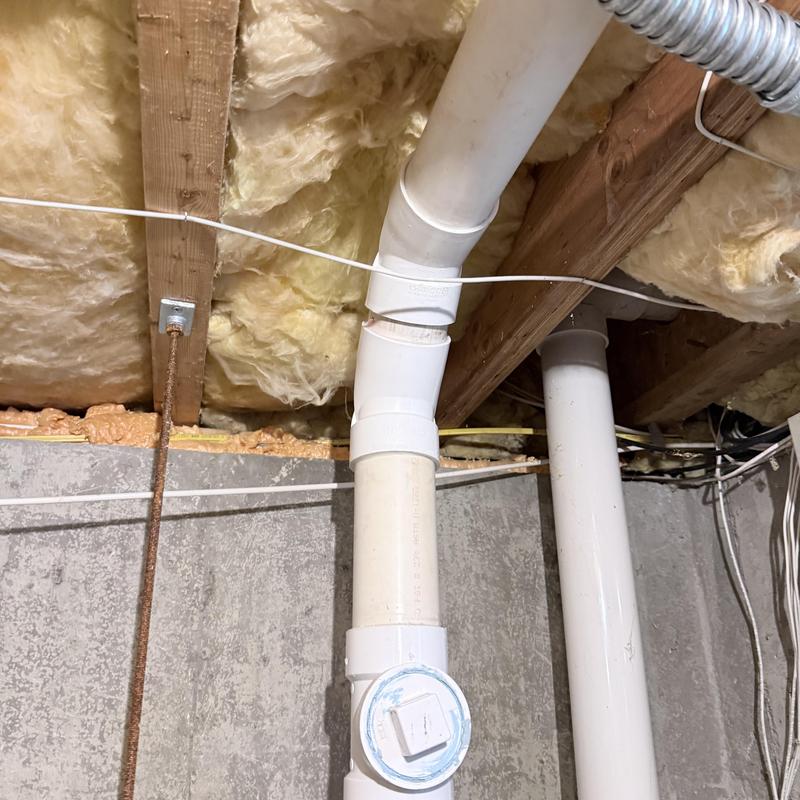 PVC drain piping with angled joint in basement ceiling