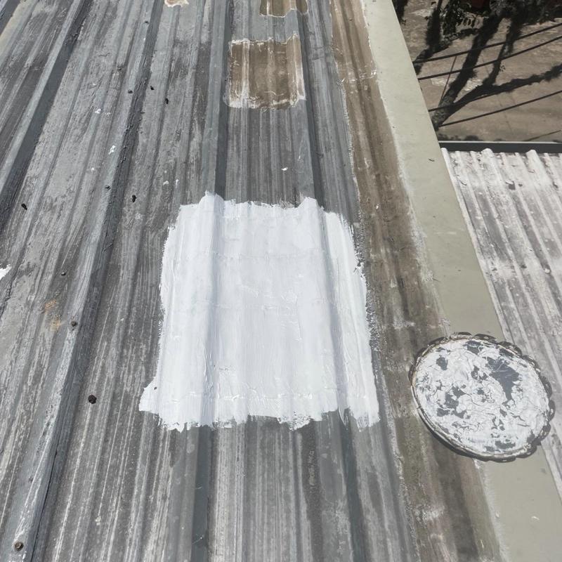 Metal roof leak patch with white sealant applied