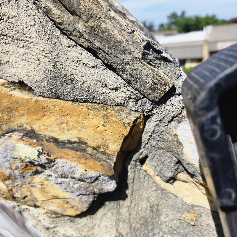 Sandstone wall cracks with mortar gaps near roof edge Sandstone wall cracks with mortar gaps near roof edge