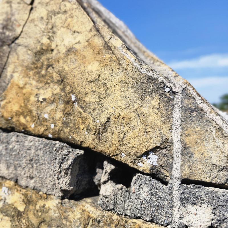 Sandstone wall with visible cracks and damage Sandstone wall with visible cracks and damage