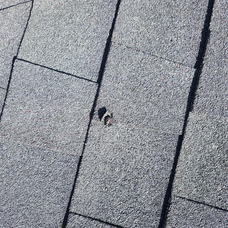 Asphalt shingle with nail pops and missing ridge shingle Asphalt shingle with nail pops and missing ridge shingle