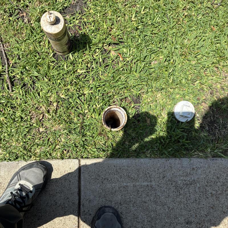 Sewer cleanout in yard with open cap and tools Sewer cleanout in yard with open cap and tools