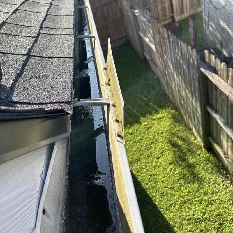 Roof drip edge misaligned behind gutter causing water buildup