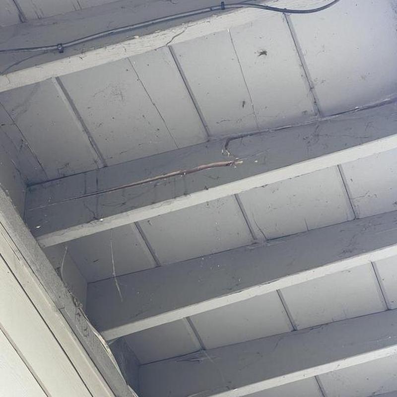 Flat roof structure with exposed beams and wiring