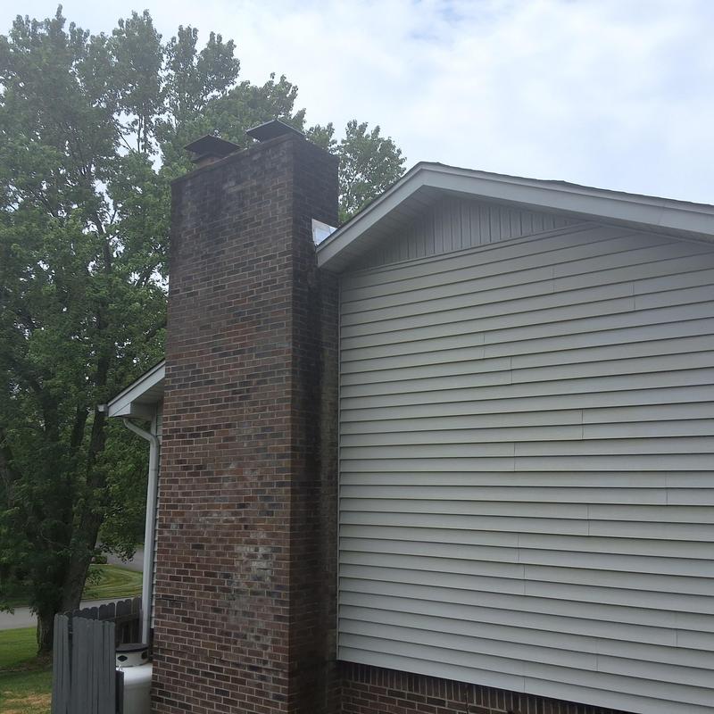 Brick chimney exterior with weathered siding paneling