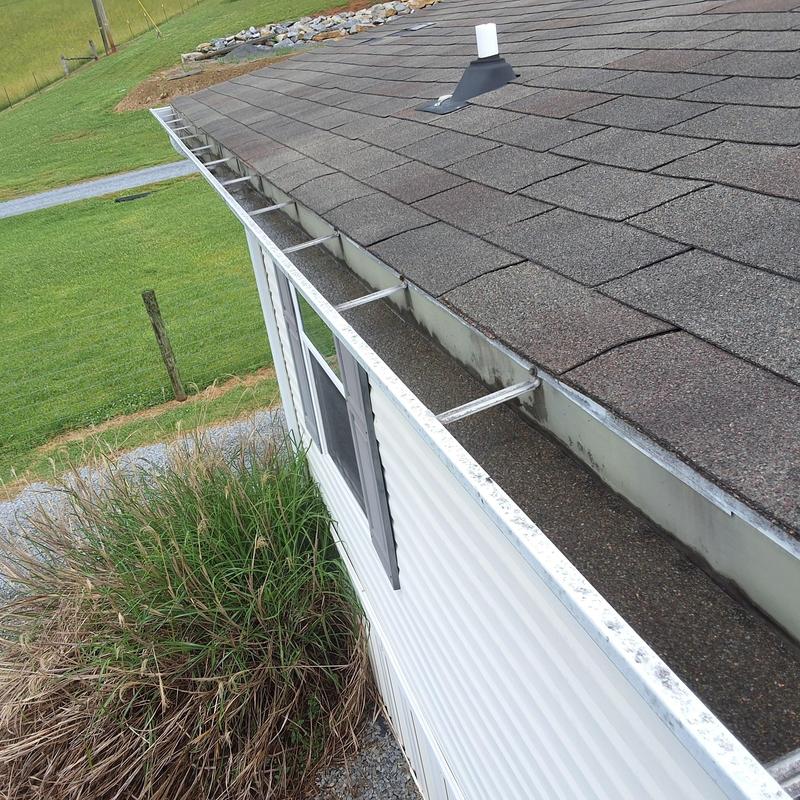 Asphalt shingle roof and clean gutter on home exterior