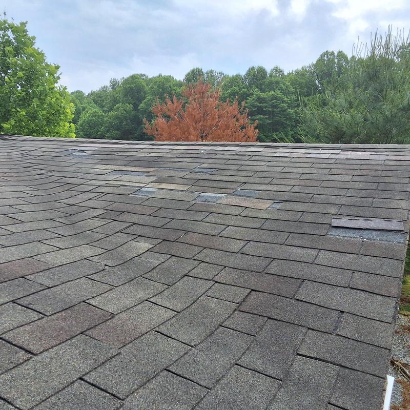 Aged asphalt shingles with patch repairs on roof