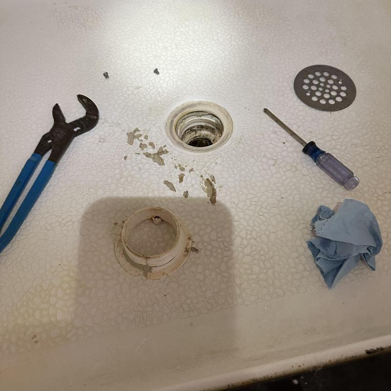 Shower drain opening with tools and removed drain cover Shower drain opening with tools and removed drain cover