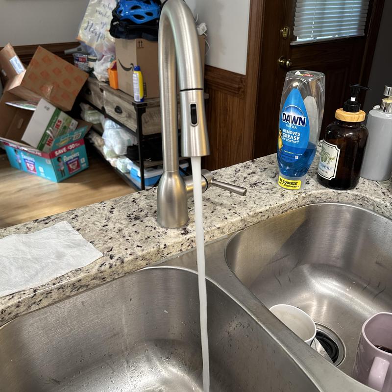 Kitchen sink faucet with running water on granite countertop Kitchen sink faucet with running water on granite countertop
