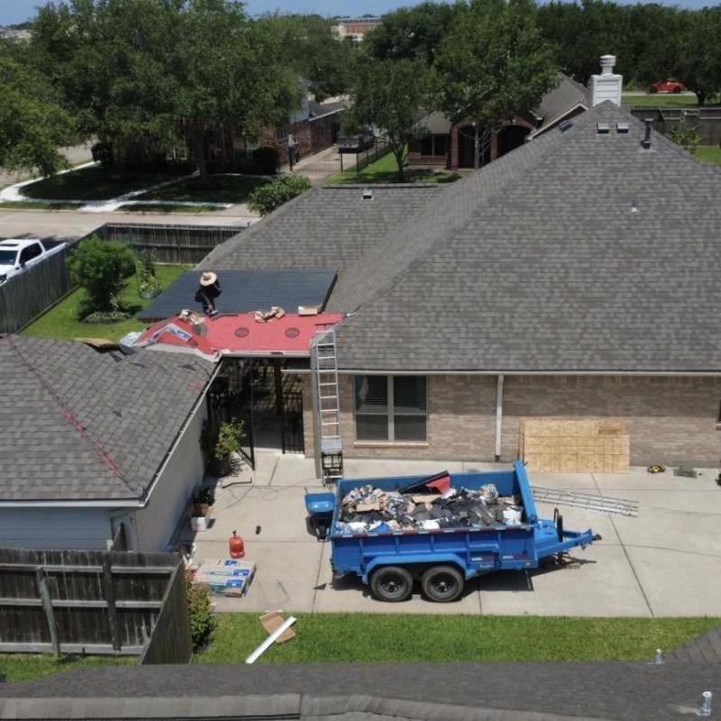 Asphalt shingle roofing installation with debris removal trailer