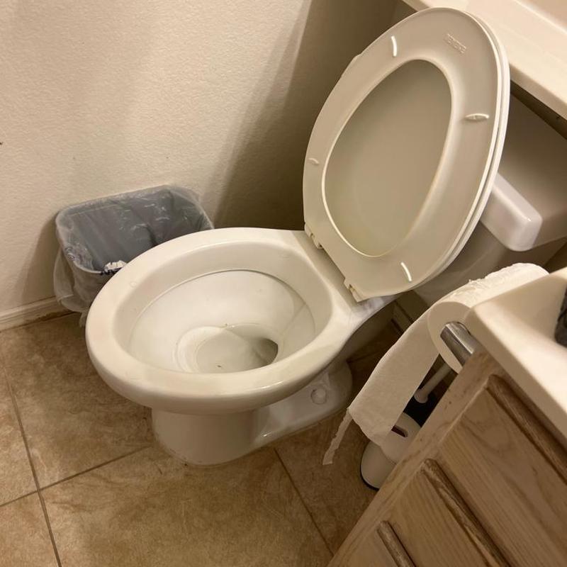 Toilet bowl with raised lid in bathroom corner Toilet bowl with raised lid in bathroom corner
