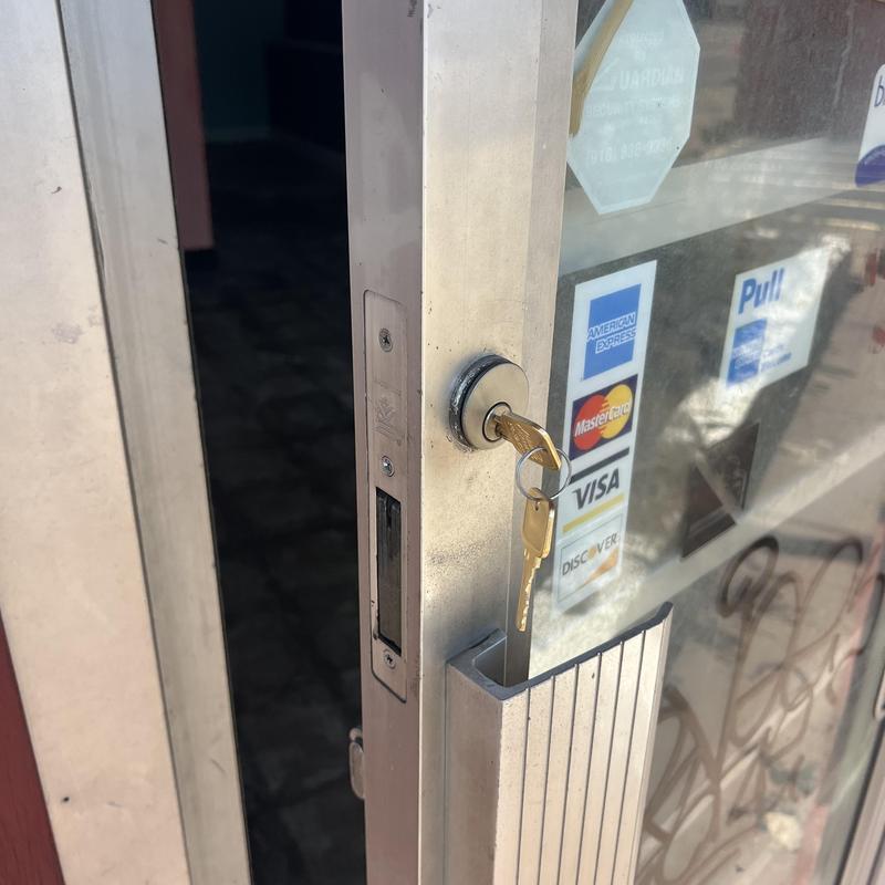 Glass door lock with key inserted at business entrance