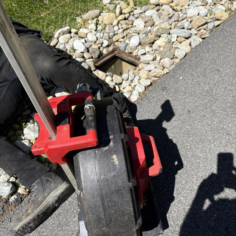 Sewer jetting machine near outdoor drain opening Sewer jetting machine near outdoor drain opening