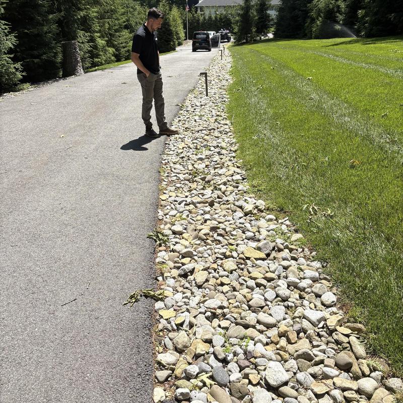 Drainage rock bed inspection by driveway in Fairfield NJ Drainage rock bed inspection by driveway in Fairfield NJ
