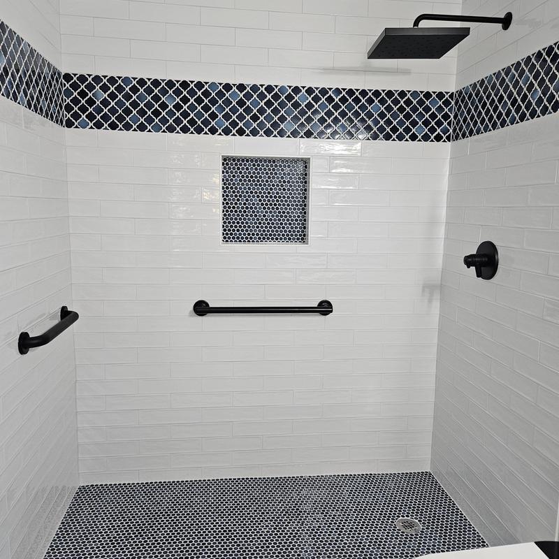 Shower tile with black grab bars and rainfall showerhead Shower tile with black grab bars and rainfall showerhead
