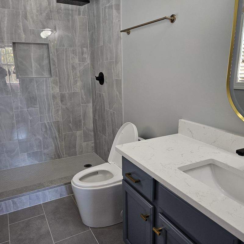 Gray tiled walk-in shower with toilet and vanity Gray tiled walk-in shower with toilet and vanity