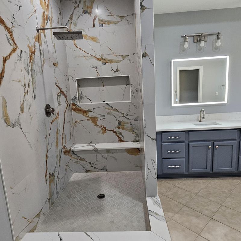 Marble tile shower with niche and bench in bathroom Marble tile shower with niche and bench in bathroom