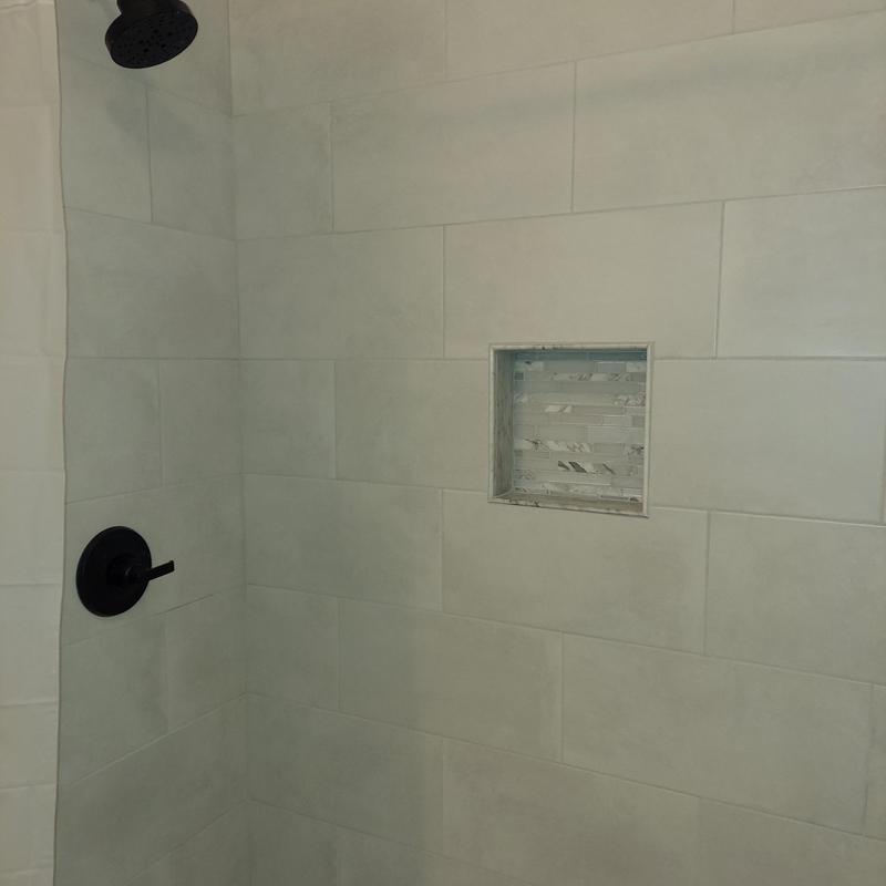 Shower wall tile with recessed niche and matte black fixtures Shower wall tile with recessed niche and matte black fixtures