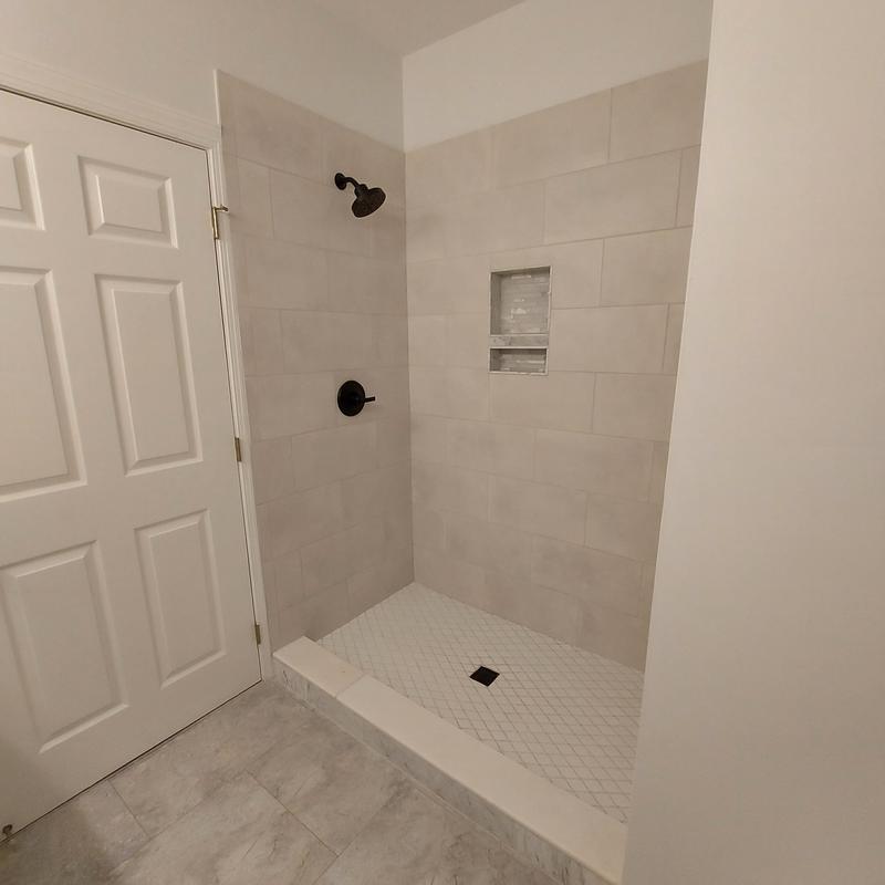 Tile shower enclosure with built-in niche and dark fixtures Tile shower enclosure with built-in niche and dark fixtures