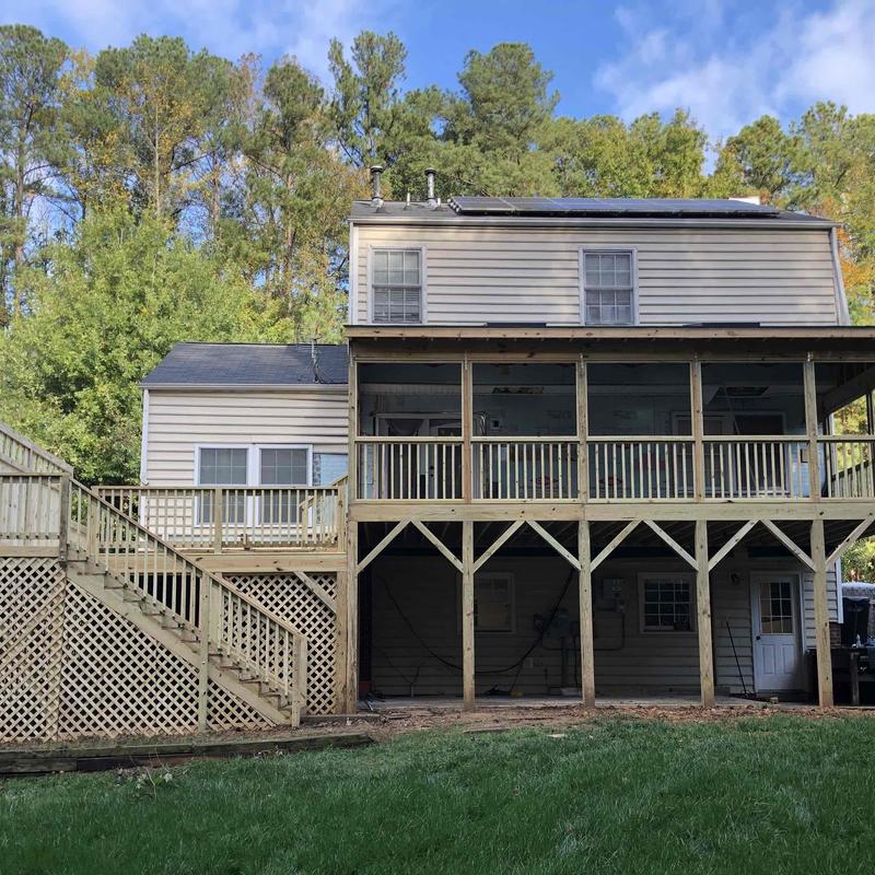 Wooden home addition deck with railing and stairs Wooden home addition deck with railing and stairs