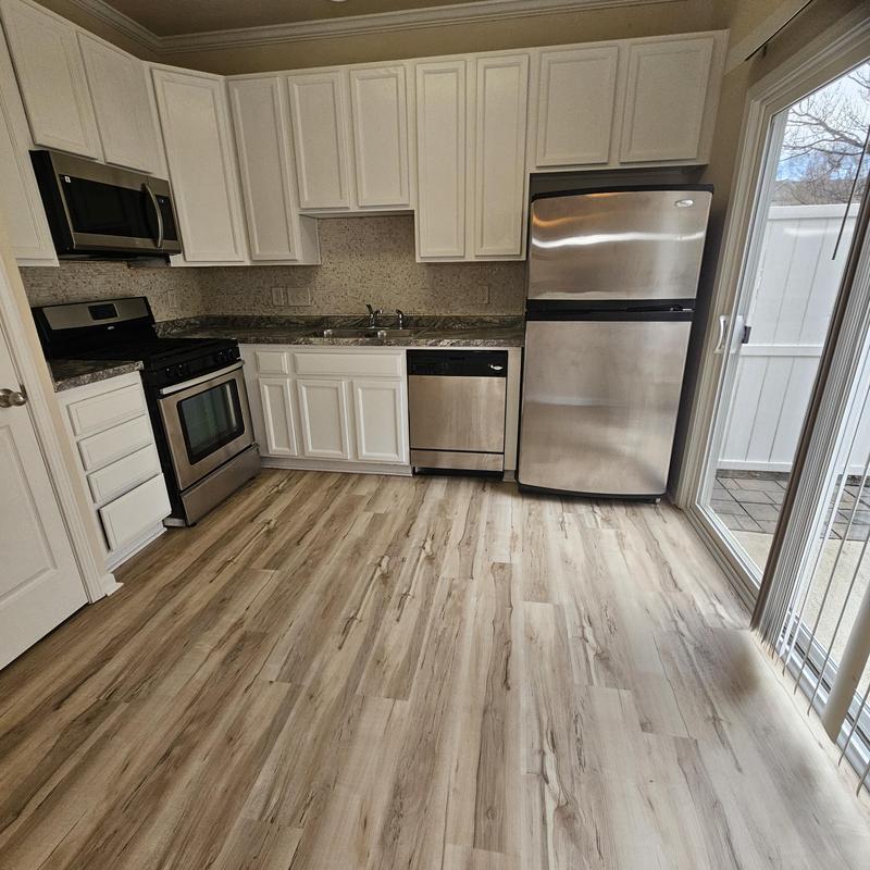 Laminate wood flooring in kitchen with stainless appliances Laminate wood flooring in kitchen with stainless appliances
