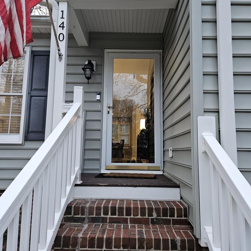 Storm door and brick front porch steps with railing Storm door and brick front porch steps with railing