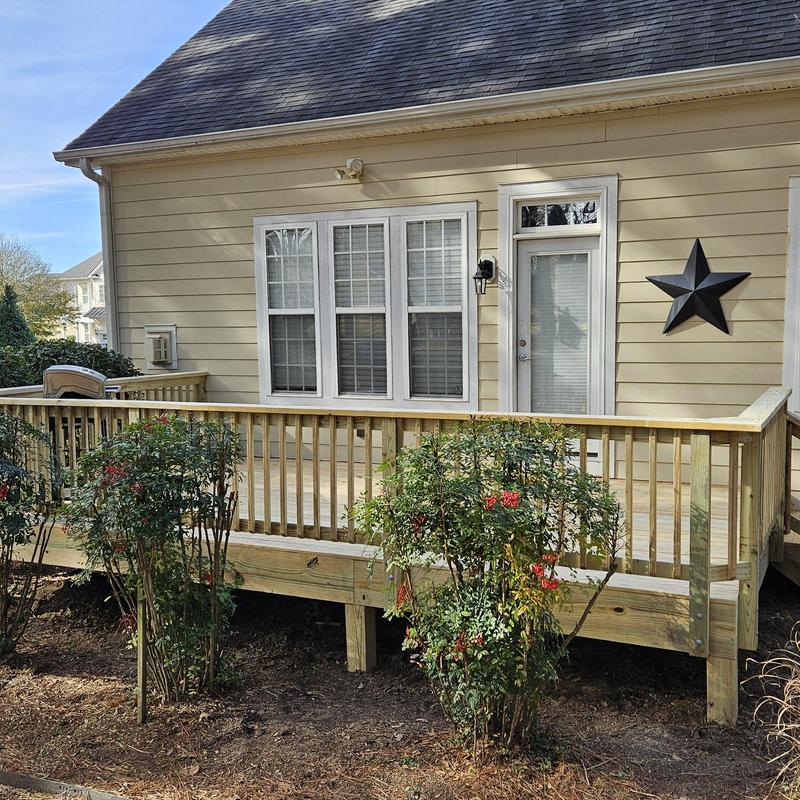 Wooden deck with railing installation on house exterior Wooden deck with railing installation on house exterior