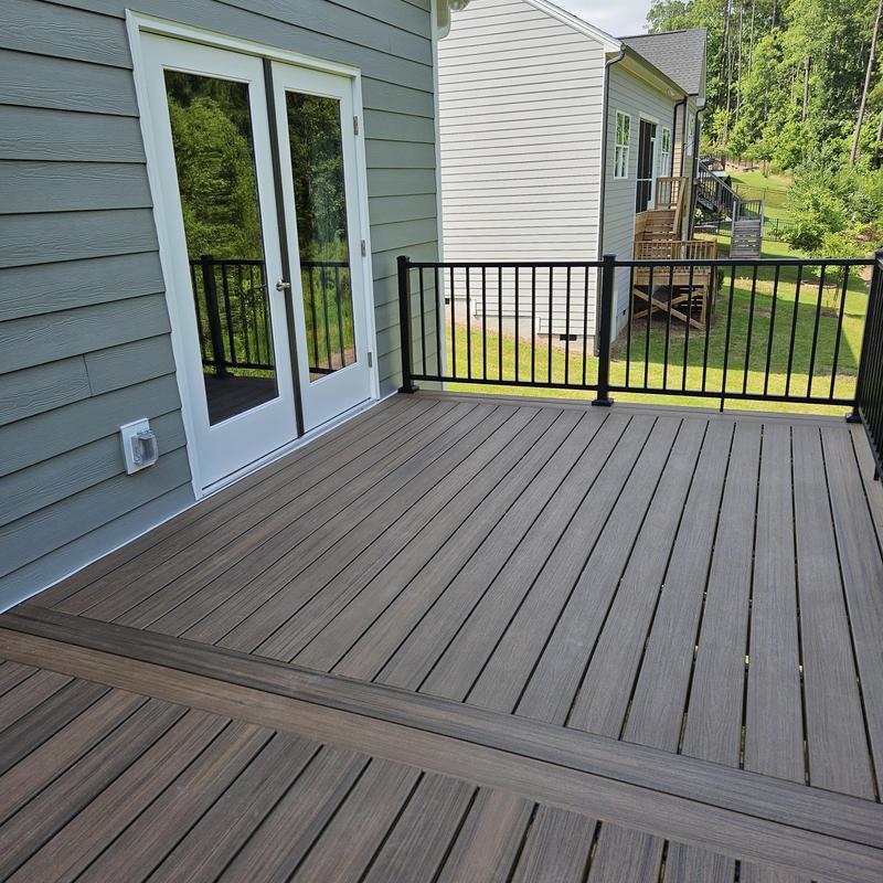 Composite deck with black metal railing in backyard Composite deck with black metal railing in backyard