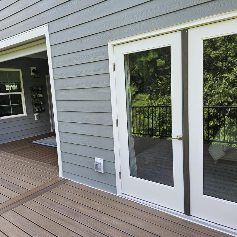 Composite deck and white framed glass doors with siding Composite deck and white framed glass doors with siding