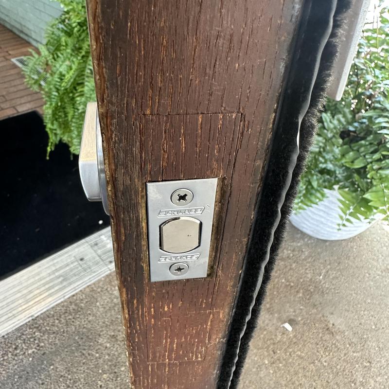 Deadbolt latch on thick wooden door frame exterior