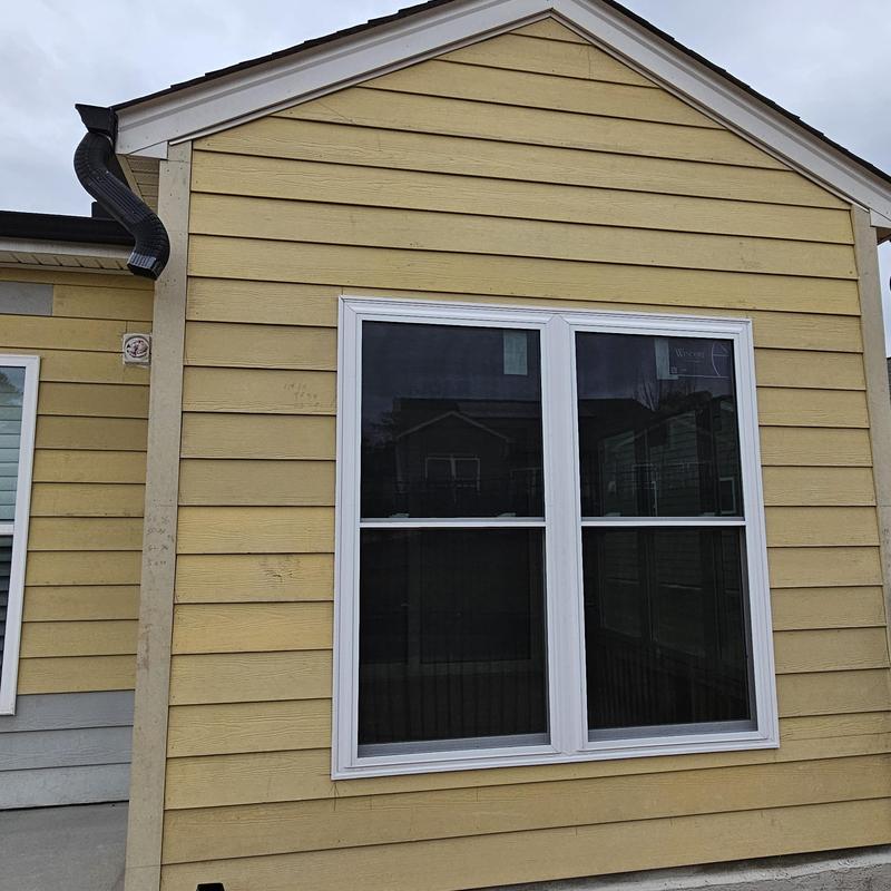 Vinyl window installation on beige siding exterior Vinyl window installation on beige siding exterior