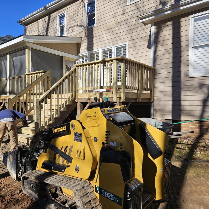 Deck construction with Vermeer mini skid steer in backyard Deck construction with Vermeer mini skid steer in backyard