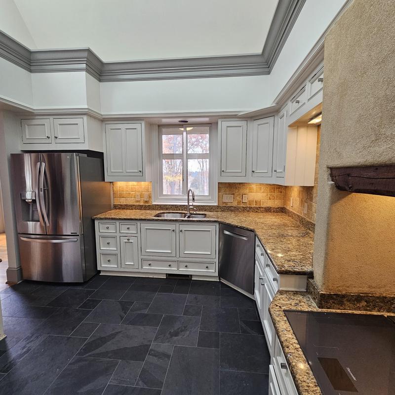 Kitchen sink area with granite countertops and white cabinetry Kitchen sink area with granite countertops and white cabinetry