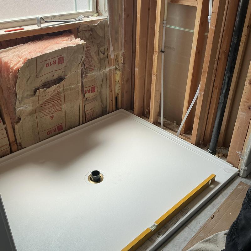 Shower drain plumbing installation with level tool