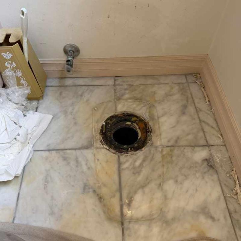 Toilet flange and water supply valve on marble floor