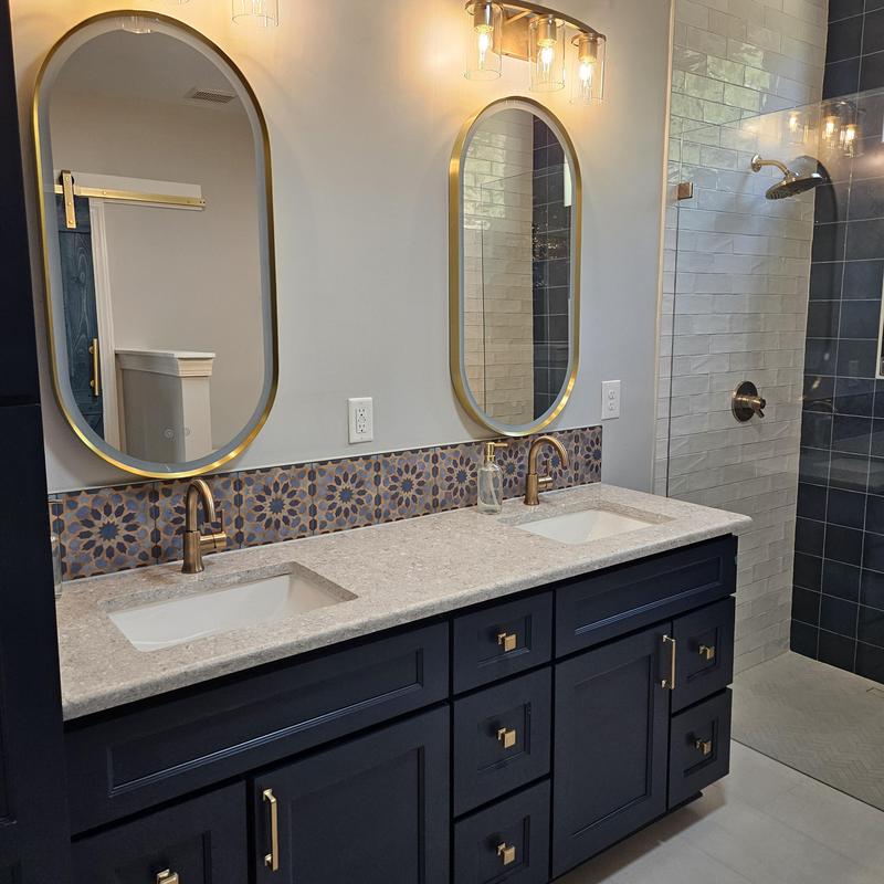 Double bathroom vanity with gold fixtures and tiled backsplash Double bathroom vanity with gold fixtures and tiled backsplash