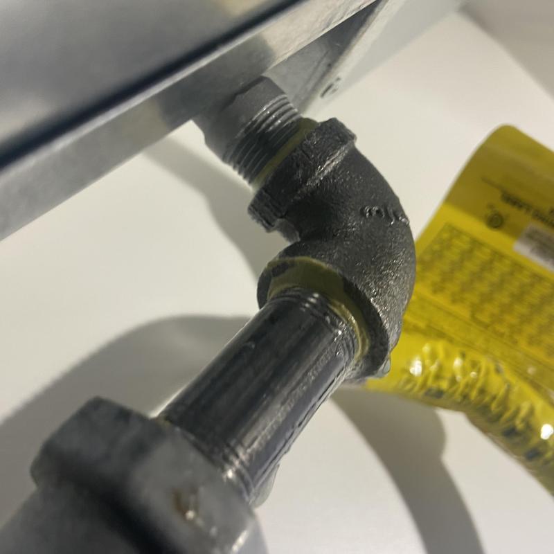 Stove top gas line with elbow fitting and tag