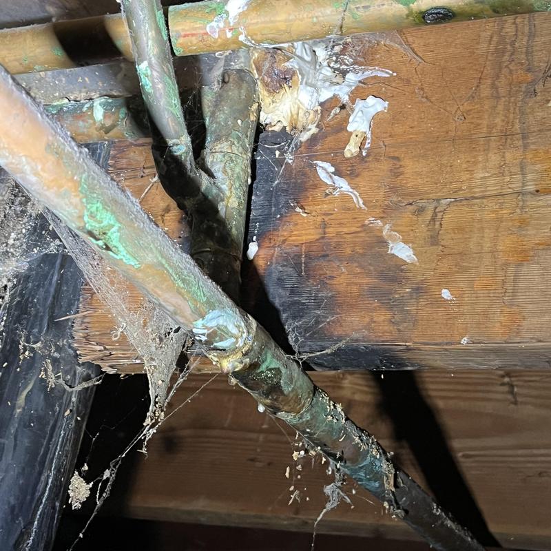 Corroded copper plumbing pipes under wooden joist Corroded copper plumbing pipes under wooden joist