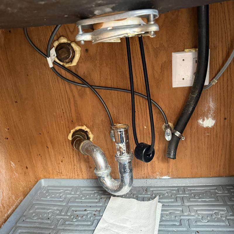 Garbage disposal and basin faucet water supply lines under sink