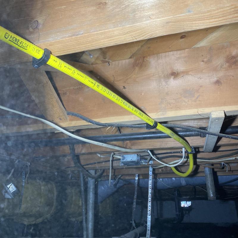 Flexible yellow gas line installed under floor joists Flexible yellow gas line installed under floor joists