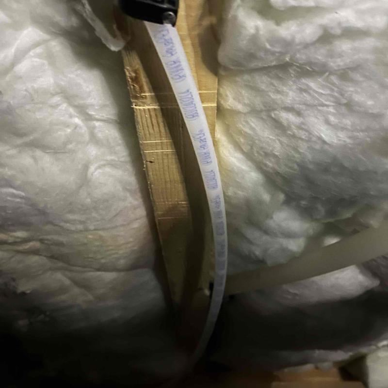 PEX water tubing installed through wooden framing with foam insulation PEX water tubing installed through wooden framing with foam insulation