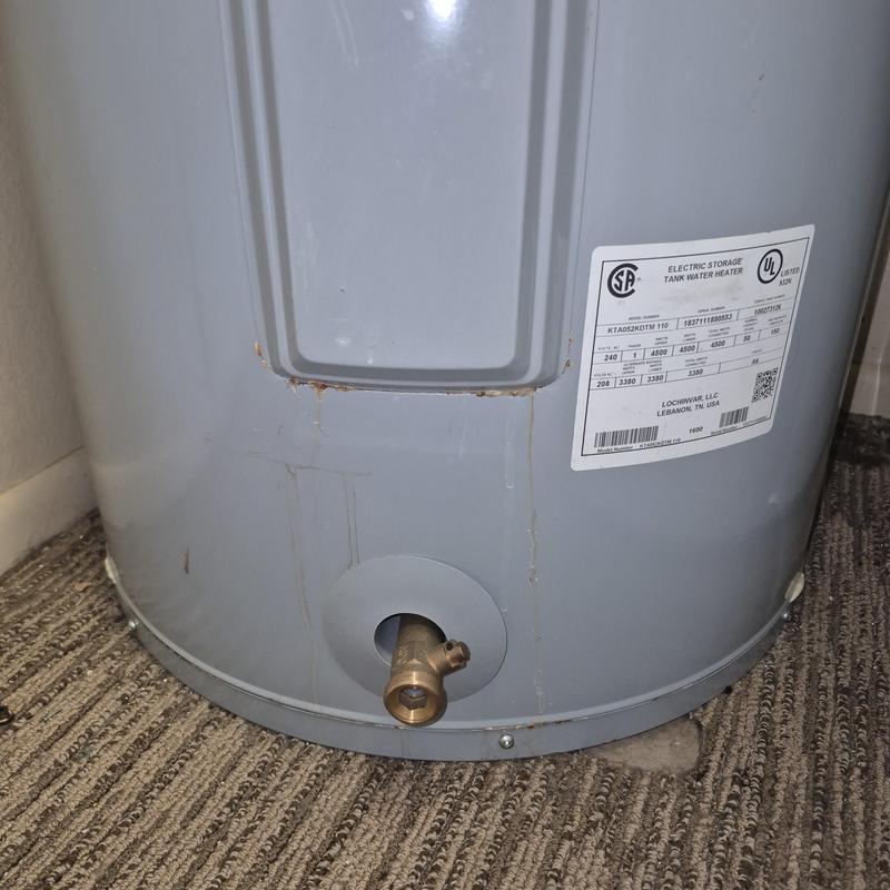 Water heater drain valve on gray electric tank heater