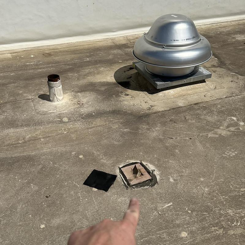Roof drain with sealant patch on flat upper roof