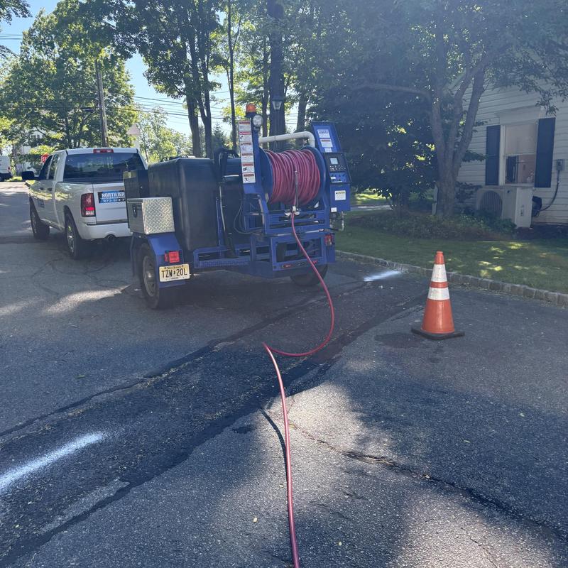 Jetting hose and truck setup on residential street Jetting hose and truck setup on residential street