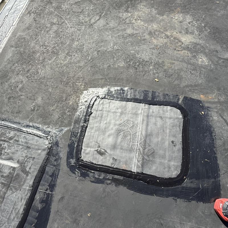 Flat roof patch with waterproof sealant applied