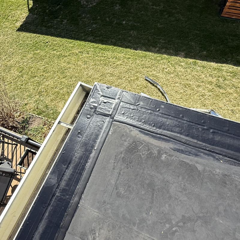 Drip edge flashing and cover strip on flat roof edge