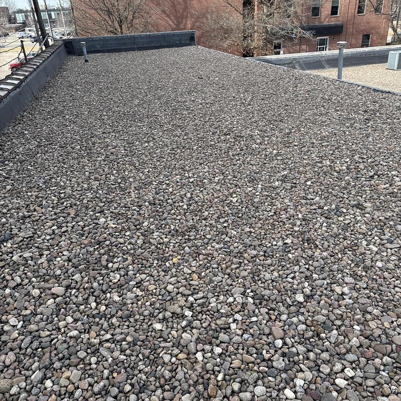 Gravel-covered commercial flat roof with drainage vents Gravel-covered commercial flat roof with drainage vents