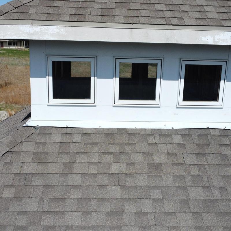 Roof shingles and fascia on dormer with three windows