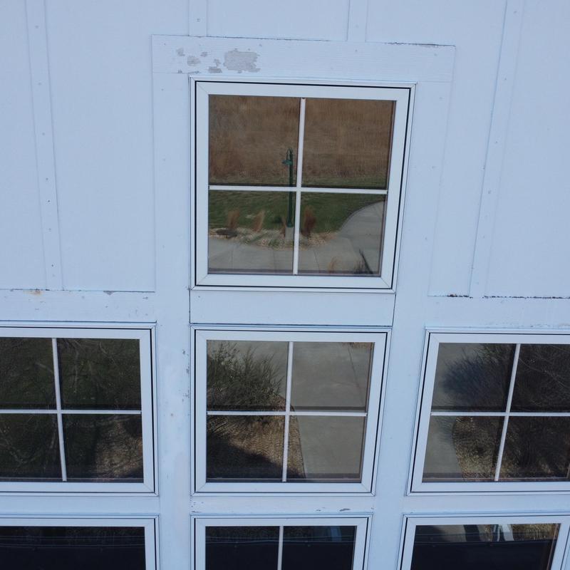 Garage door window panel with peeling paint above